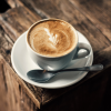 Tasse Cappuccino mit Latte-Art auf einem Holztisch
