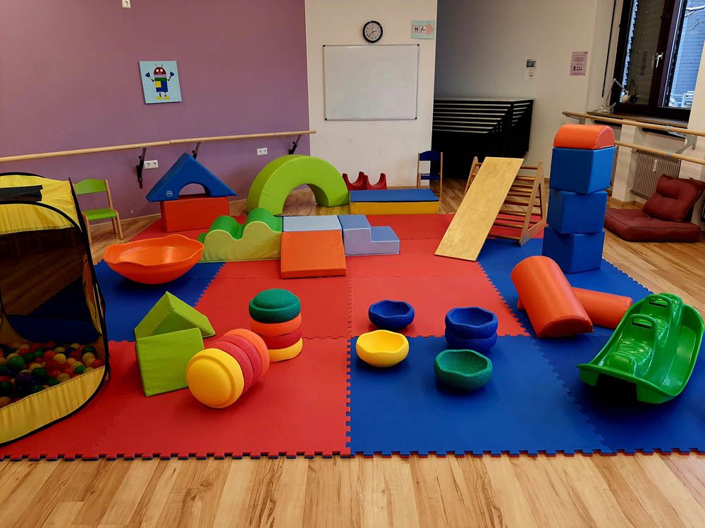 Kinderspielecke mit bunten Teppichen und großen bunten Spielklötzen