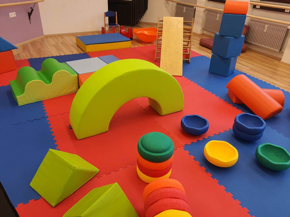 Kinderspielecke mit bunten Teppichen und großen bunten Spielklötzen