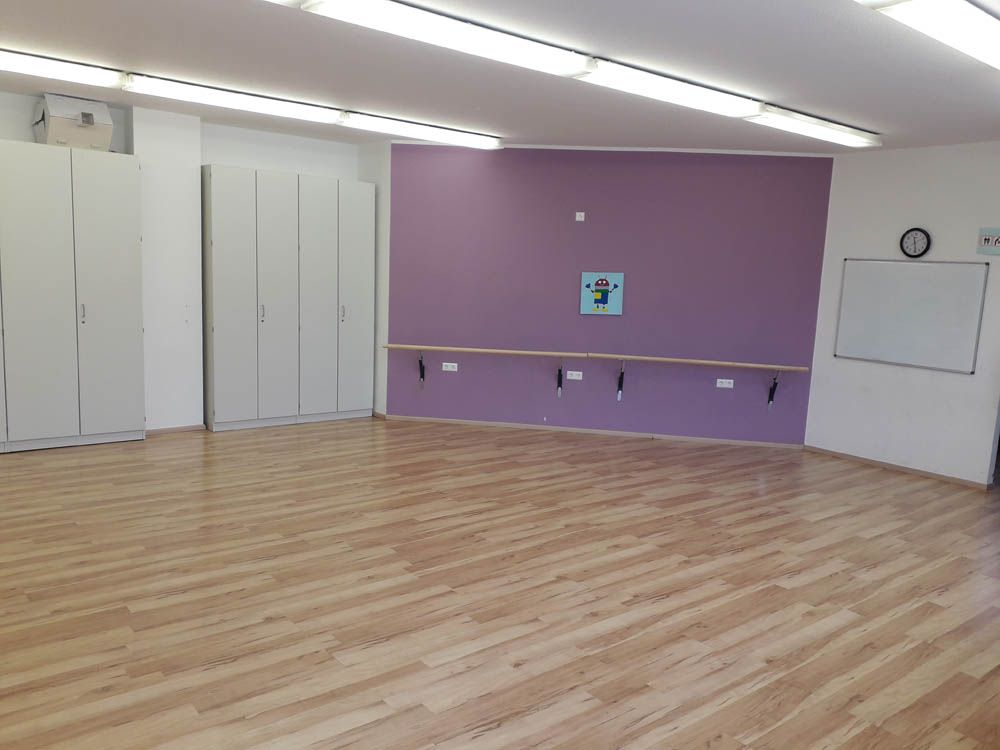 Gruppenraum mit Haltestangen vor einer fliederfarbenen Wand