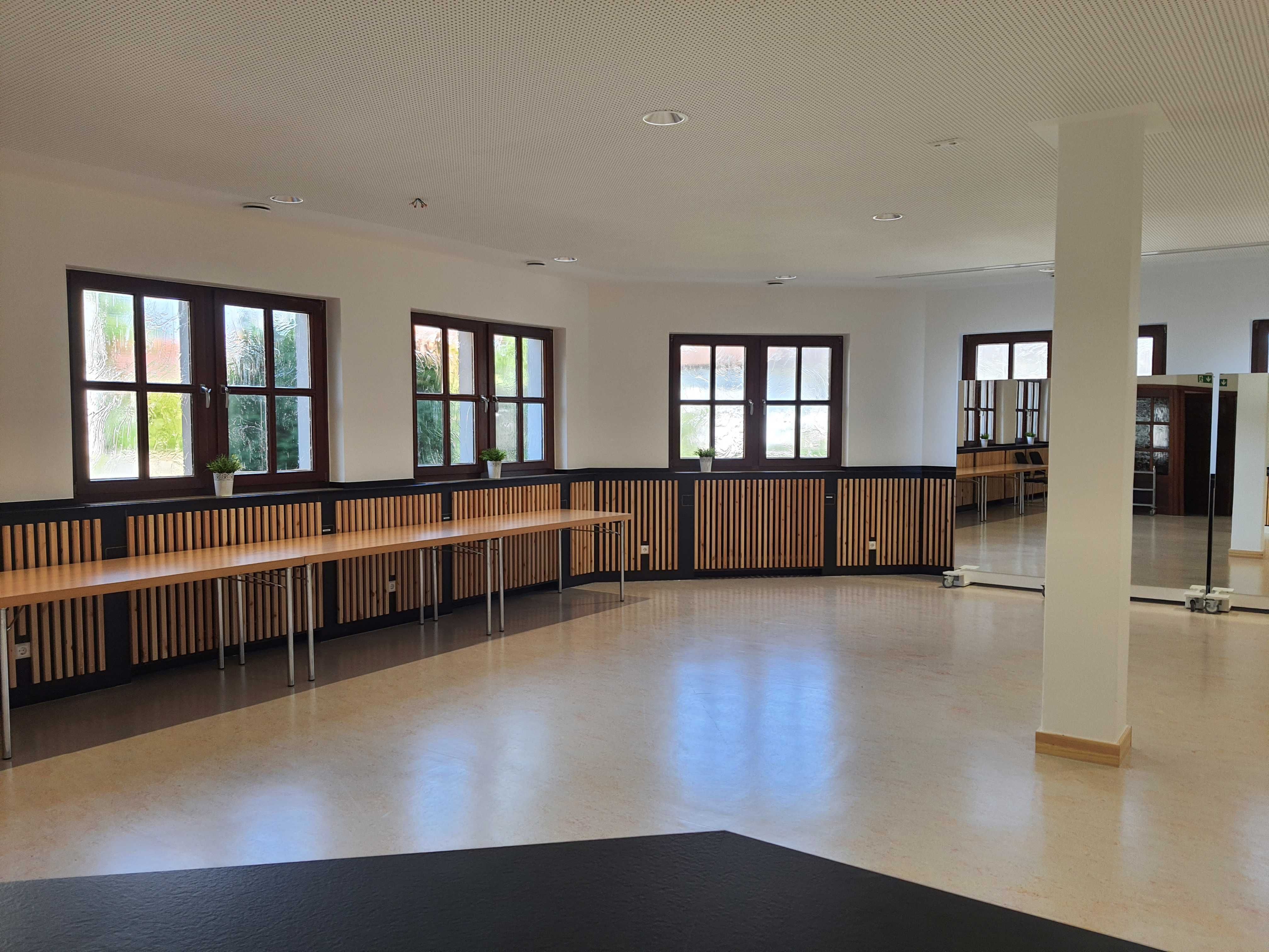 Seminarraum mit Tischen vor einer Fensterreihe